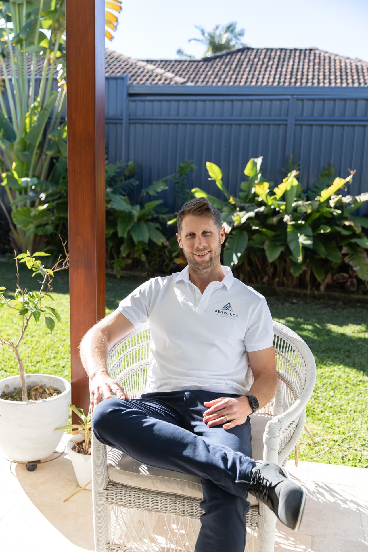 Jim Morrison sitting outdoors in an Absolute Mortgage & Finance polo shirt